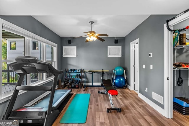 exercise room featuring ceiling fan, wood finished floors, visible vents, and baseboards