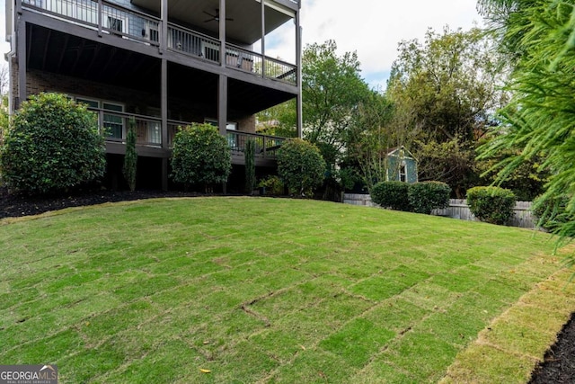 view of yard with fence and a ceiling fan