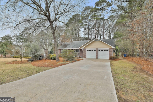 single story home with driveway, brick siding, a front lawn, and an attached garage