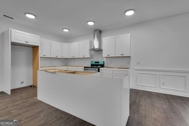 124 Wright St, Savannah, GA 31408 - kitchen with dark wood-style flooring, white cabinetry, stainless steel range with electric cooktop, a center island, and wall chimney exhaust hood