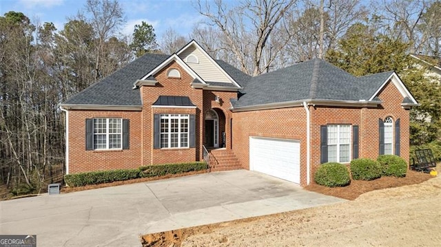 traditional-style house featuring driveway, a shingled roof, an attached garage, and brick siding