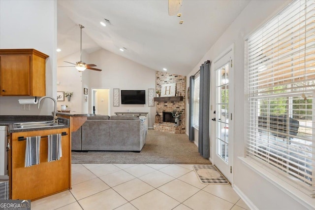 living room with a brick fireplace, light tile patterned floors, high vaulted ceiling, and light colored carpet