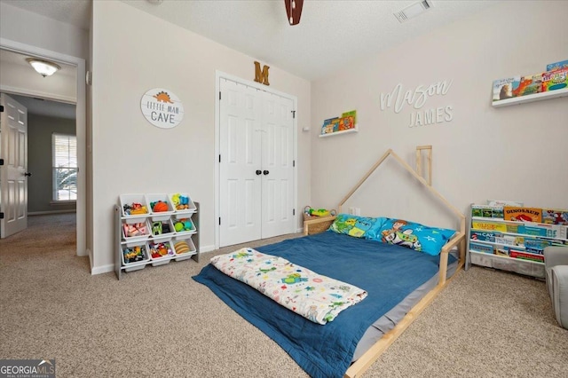 bedroom with ceiling fan, carpet floors, visible vents, baseboards, and a closet