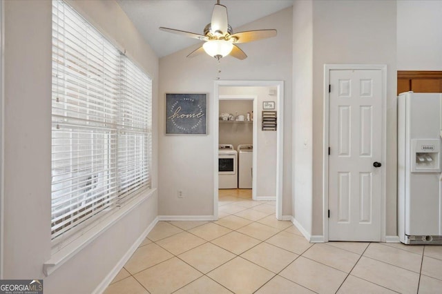 hall featuring light tile patterned floors, vaulted ceiling, independent washer and dryer, and baseboards