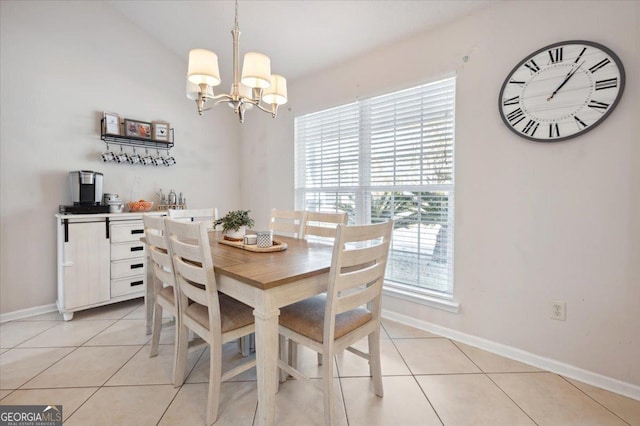 dining area with light tile patterned floors, baseboards, and an inviting chandelier