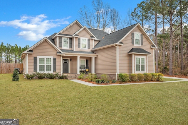 craftsman house featuring covered porch, central AC, fence, and a front lawn