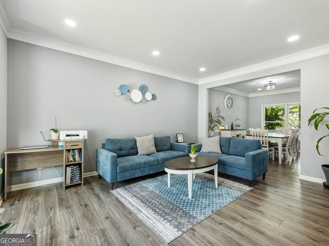 living area featuring ornamental molding, recessed lighting, baseboards, and wood finished floors