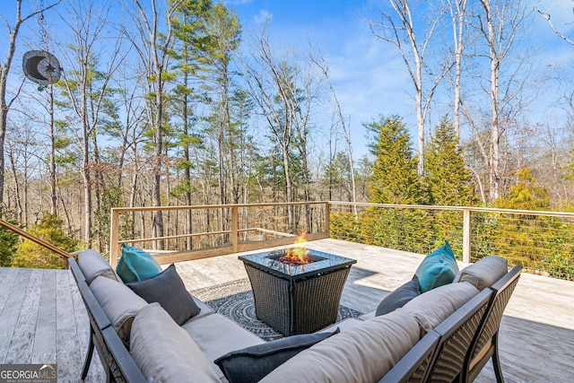 deck with an outdoor living space with a fire pit