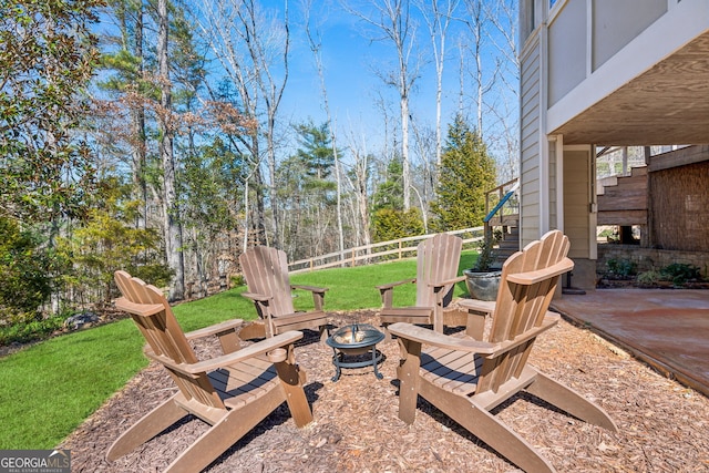 view of patio featuring an outdoor fire pit, stairway, and fence