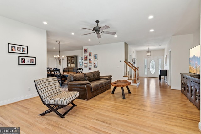 living room featuring light wood-style floors, recessed lighting, baseboards, and stairs