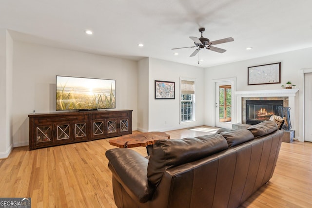 living area featuring baseboards, a tile fireplace, light wood-style flooring, ceiling fan, and recessed lighting