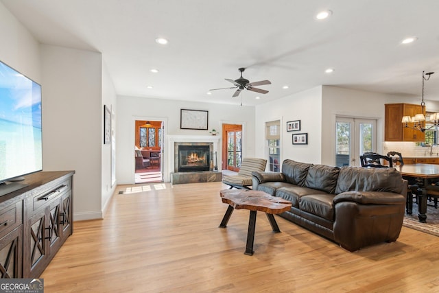 living area with light wood-style floors, recessed lighting, and a tiled fireplace