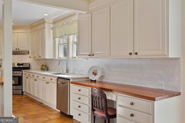 kitchen featuring appliances with stainless steel finishes, wooden counters, under cabinet range hood, and a sink