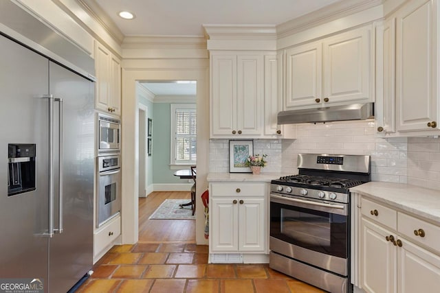 kitchen with under cabinet range hood, ornamental molding, backsplash, and built in appliances