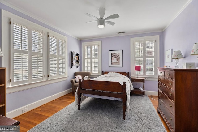 bedroom with ornamental molding, multiple windows, and visible vents