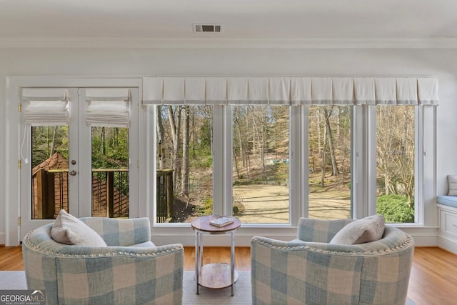 sunroom / solarium featuring french doors, visible vents, and a healthy amount of sunlight