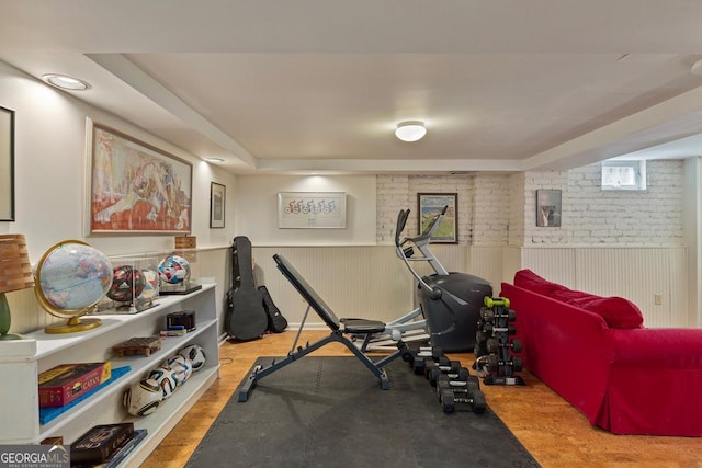 exercise room featuring a wainscoted wall and wood finished floors