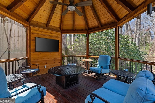 sunroom with vaulted ceiling with beams, wooden ceiling, and a ceiling fan