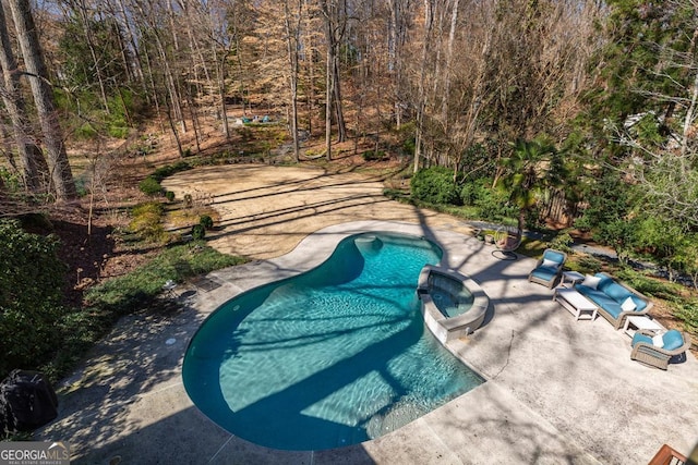 view of swimming pool with a patio area and a hot tub