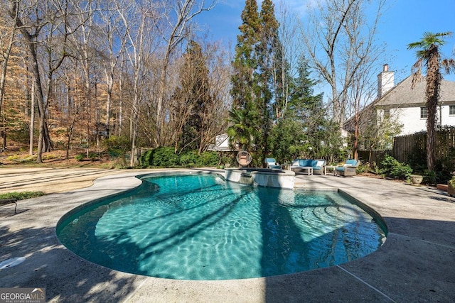 view of pool featuring a pool with connected hot tub, a patio, an outdoor living space, and fence