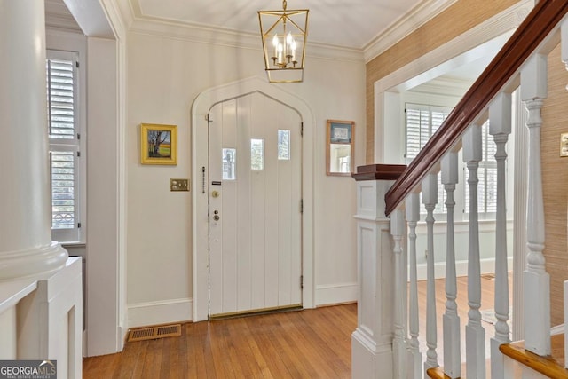 entryway featuring visible vents, crown molding, light wood-style flooring, and stairs