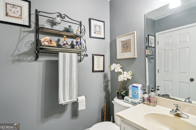 half bathroom featuring vanity and toilet