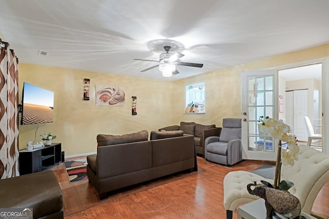 living room with baseboards, a ceiling fan, wood finished floors, and french doors