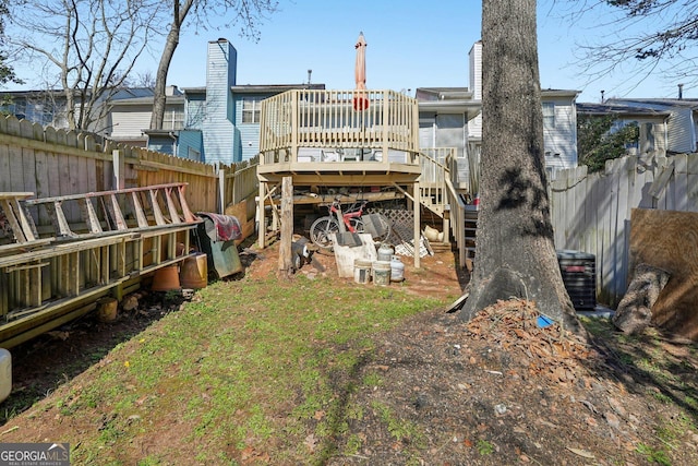 rear view of house with a deck and a fenced backyard