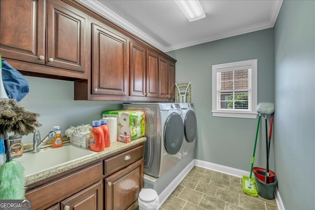 washroom featuring cabinet space, washing machine and dryer, ornamental molding, and a sink