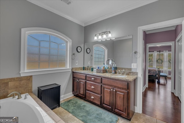 full bathroom with double vanity, ensuite bath, a sink, and crown molding