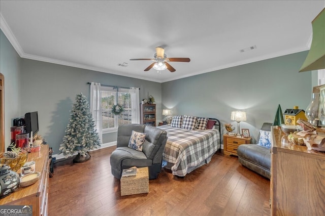 bedroom featuring crown molding, visible vents, and wood finished floors