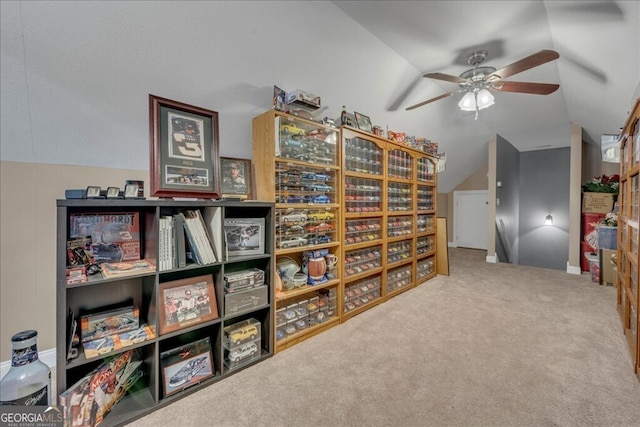 living area with vaulted ceiling, ceiling fan, and carpet flooring