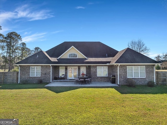 rear view of house featuring a yard, fence, and a patio