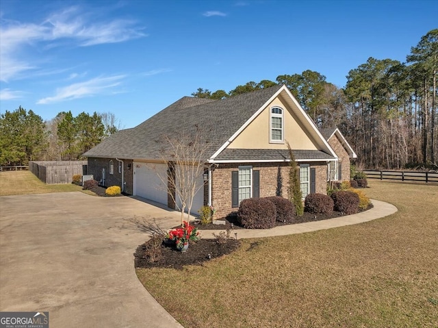 view of front of home featuring concrete driveway, an attached garage, fence, a front lawn, and brick siding