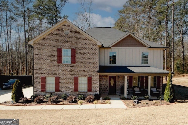 view of front of home featuring covered porch, board and batten siding, and brick siding