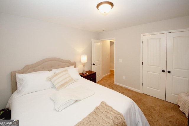 bedroom featuring baseboards, a closet, and light colored carpet