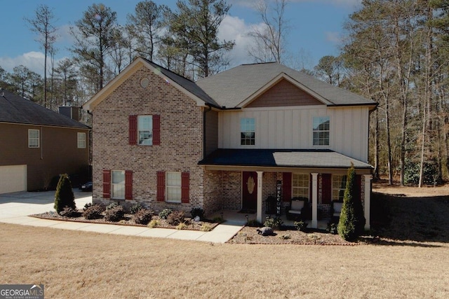 view of front of property featuring a porch, brick siding, board and batten siding, and a front lawn