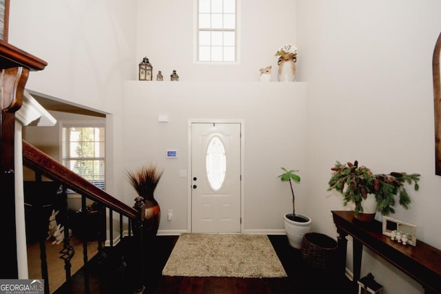 foyer entrance with stairs and a towering ceiling