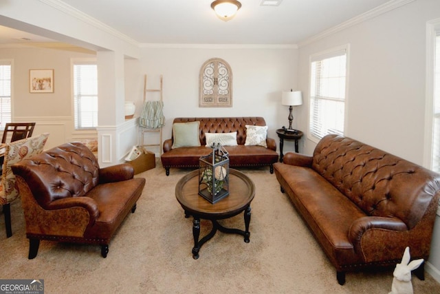 living area with visible vents, a decorative wall, ornamental molding, wainscoting, and light carpet