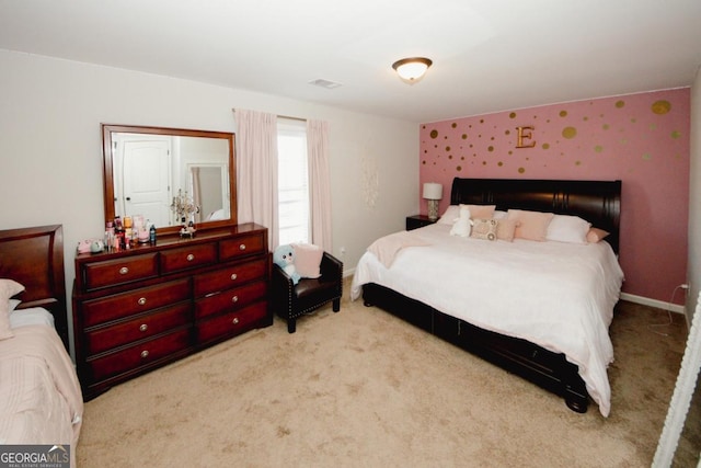 bedroom with light carpet, visible vents, and baseboards