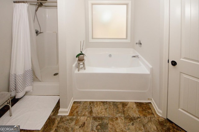 bathroom featuring walk in shower and a garden tub