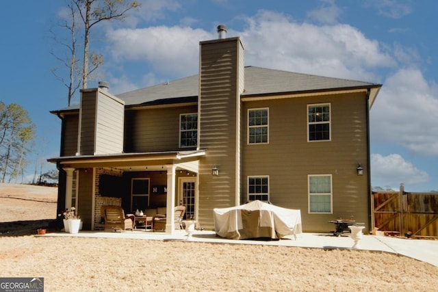 rear view of house featuring a patio and a chimney