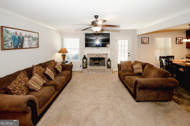 living area featuring ornamental molding, a brick fireplace, light carpet, and a ceiling fan