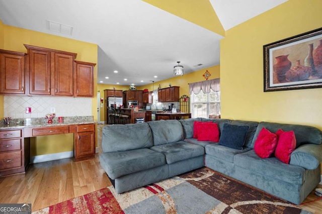 living area featuring light wood finished floors, visible vents, and recessed lighting