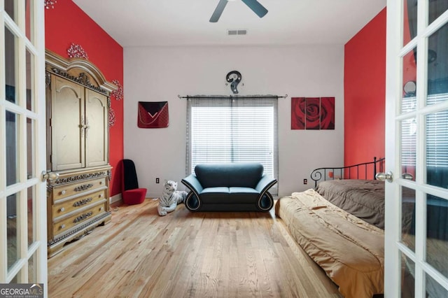 bedroom with french doors, wood finished floors, visible vents, and a ceiling fan