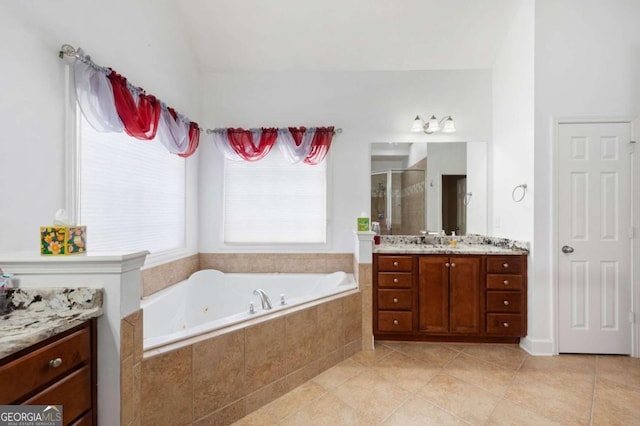 bathroom with a bath, a shower stall, tile patterned flooring, and vanity