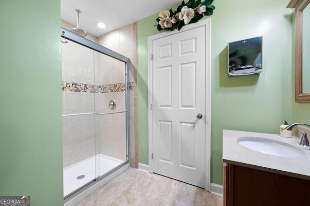 bathroom with a shower stall and vanity
