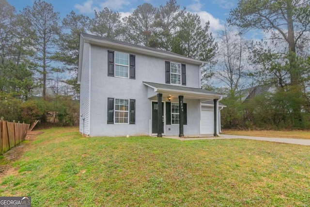 traditional-style home with a garage, fence, driveway, stucco siding, and a front yard