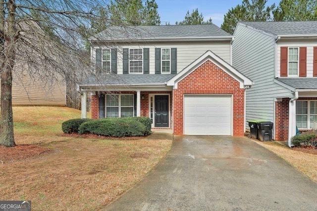 view of front of property with an attached garage, brick siding, driveway, and a front lawn