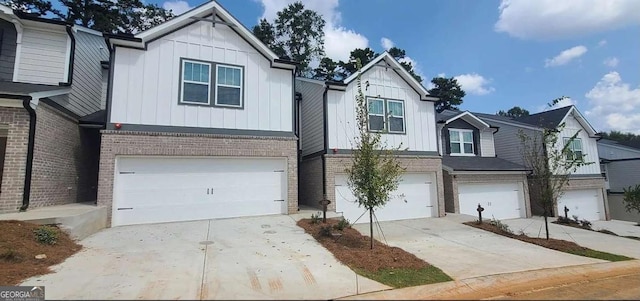 view of front of house with board and batten siding, brick siding, driveway, and an attached garage